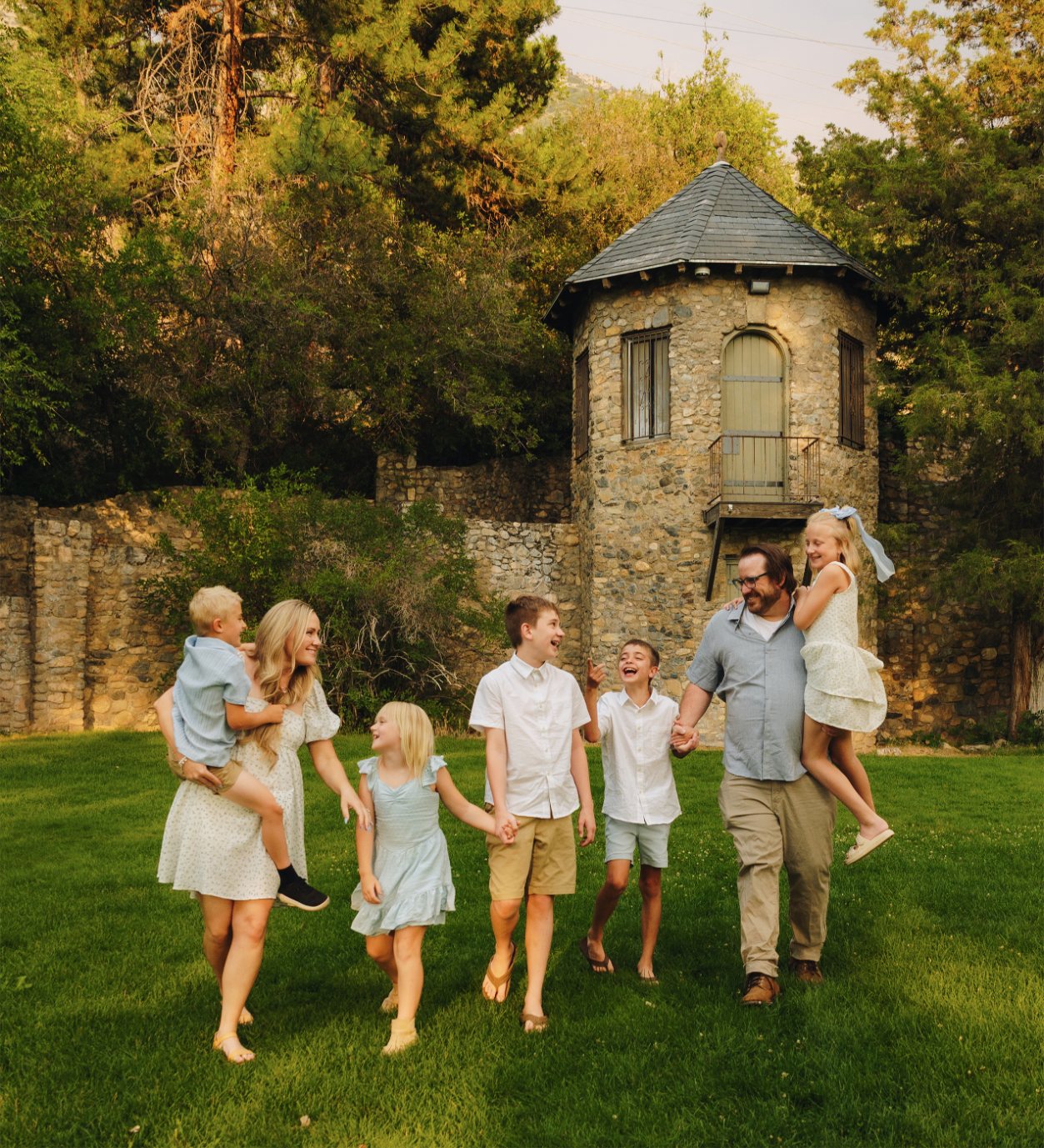 Collin, Becca and the kids walking hand in hand in front of a stone tower